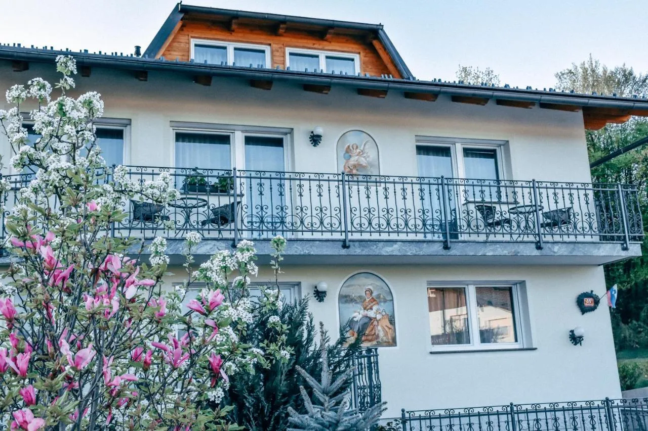 Bela hiša s kovanimi balkoni, poslikavami na fasadi in cvetočo magnolijo