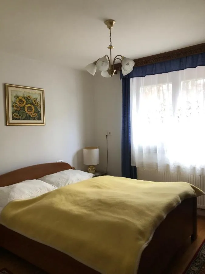 Dvoposteljna soba z zakonsko posteljo in sliko sončnic nad njo
